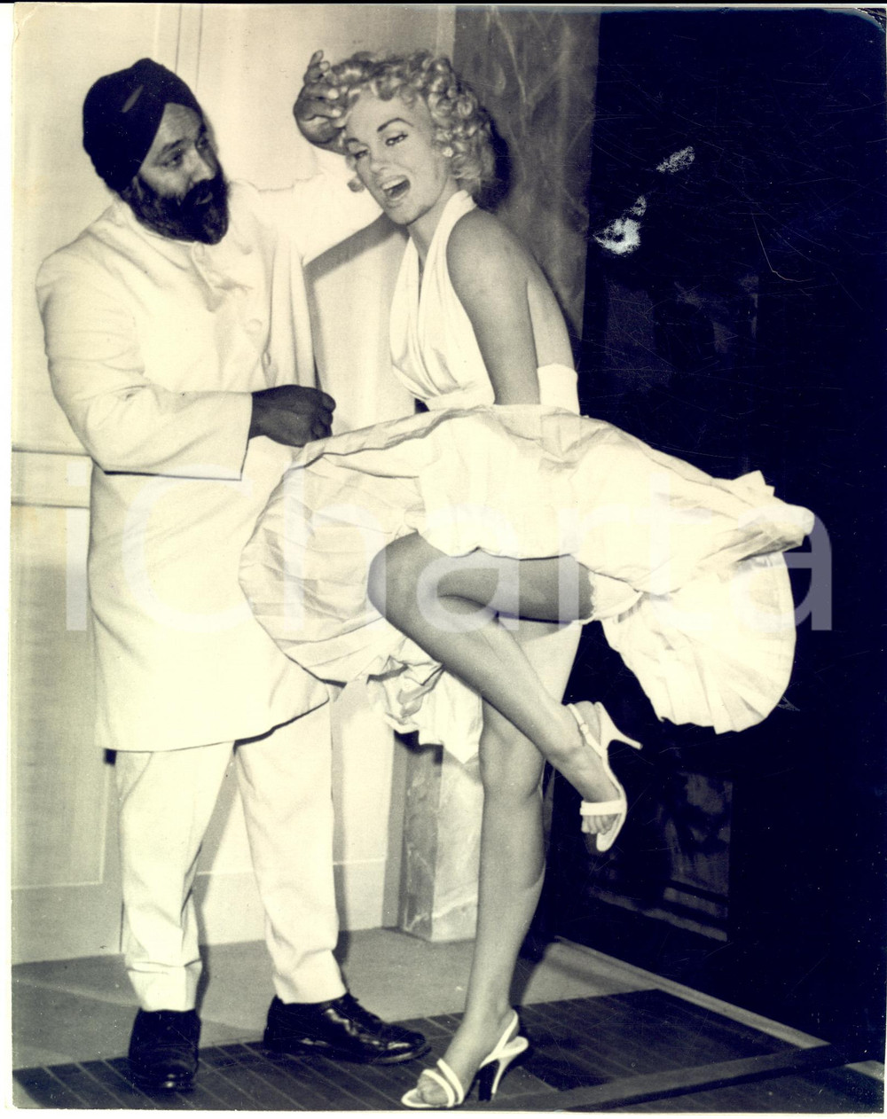 1966 HOLLYWOOD Wax Museum - SPOONY SINGH with the wax figure of Marilyn Monroe  Fotografia originale di agenzia, con didascalia coeva al verso.CONDIZIONI: POOR (piegature marginali e agli angoli del lato superiore; difetti di stampa)FORMATO: 20x26 cm    originale e autentica 1