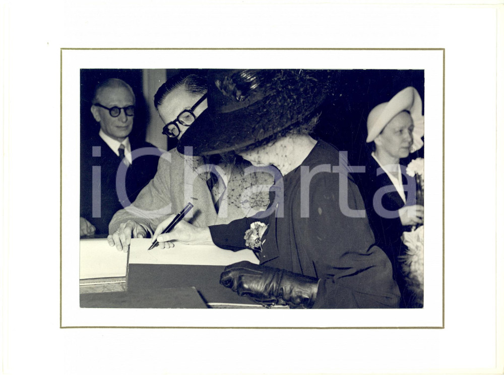 1947 BRUXELLES Reine Elisabeth signe livre d'or "Amis de Romain Rolland" - Photo  Fotografia d'epoca, incorniciata con passepartout in cartoncino e fissata con adesivo al retro.La fotografia reca al verso la didascalia originale dell'epoca.CONDIZIONI: G (ma lievi rigature)FORMATO: 18x13 cm (fotografia); 24x18 cm (cartoncino)    originale e autentica 1
