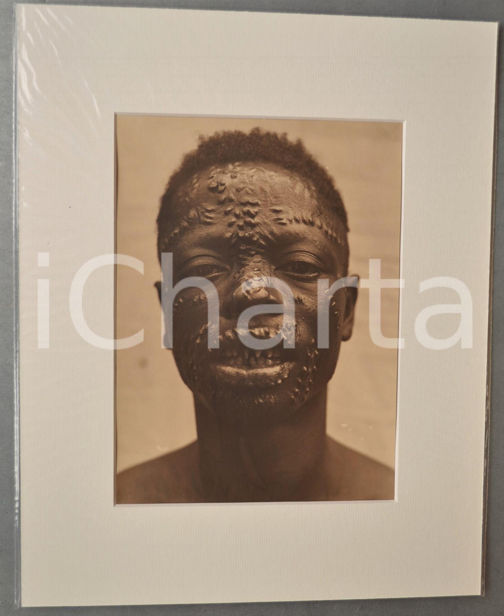 1950 ca AFRICA Ritratto di giovane uomo - Scarificazione - Foto DONCQ 28x35 RARA  Fotografia originale d'epoca, incorniciata con passepartout in cartoncino pesante e fissata con adesivo al retro.Velina protettiva.FOTOGRAFO: Jacques DoncqCONDIZIONI: GFORMATO: 18x24 cm (fotografia); 28x35 cm (cartoncino)    originale e autentica 1