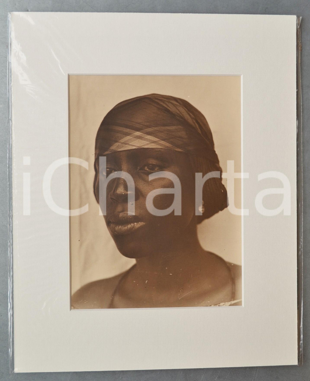 1950 ca AFRICA Ritratto di donna con foulard - Foto Jacques DONCQ 28x35  Fotografia originale d'epoca, incorniciata con passepartout in cartoncino pesante e fissata con adesivo al retro.Velina protettiva.FOTOGRAFO: Jacques DoncqCONDIZIONI: G (lievi difetti di stampa)FORMATO: 18x24 cm (fotografia); 28x35 cm (cartoncino)    originale e autentica 1