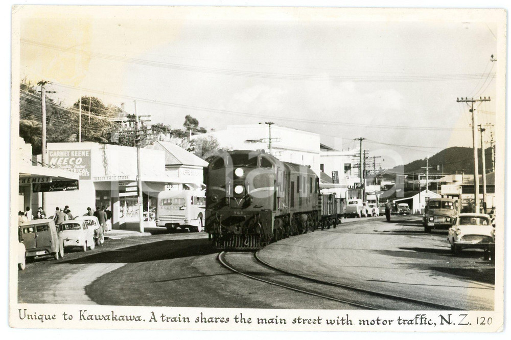 1965 ca NEW ZEALAND Unique to KAWAKAWA - A train shares the main street - RPPC  Fotocartolina postale d'epoca, viaggiata.CONDIZIONI: POOR (ingiallimenti marginali e piccole smussature angolari) FORMATO: FP    originale e autentica 1
