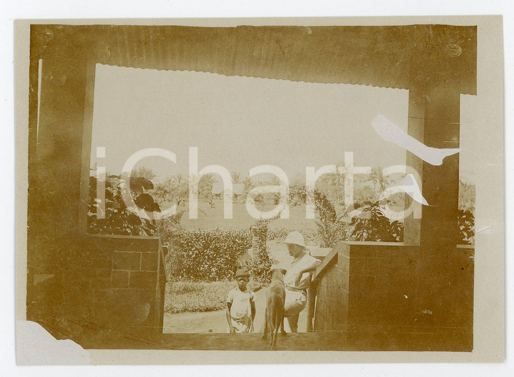 1930 ca CONGO BELGE Belgian with dog in his african house - Photo 12x9 cm Fotografia d'epoca. VERY POOR/gravemente danneggiato Lievi smussature agli angoli, estese abrasioni al verso Formato: 12x9 originale e autentica 1