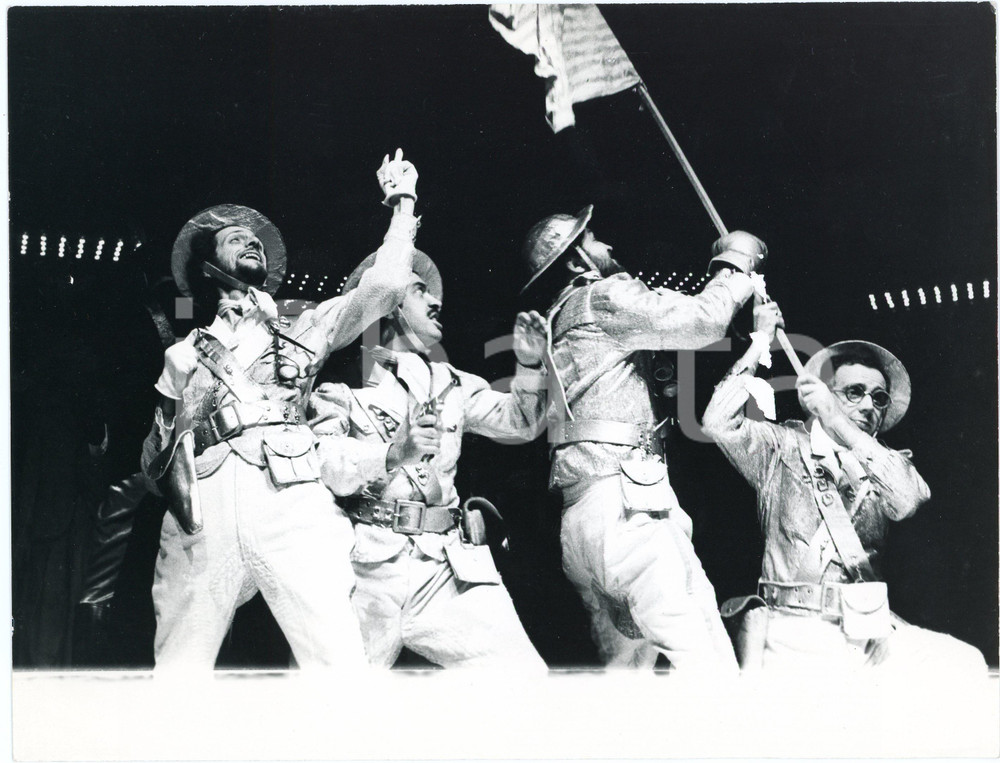 1975 BRESCIA Compagnia della Loggetta "Un uomo è un uomo" Regia M. CASTRI  Fotografia originale, con timbro e didascalia al verso.Sono presenti in scena: Gigi Castejon, Sandro De Paoli, Roberto Piumini ed Ermes Scaramelli. GOOD/buono ma minimi fori di affissione al lato superiore Formato: 24x18 cm originale e autentica 1