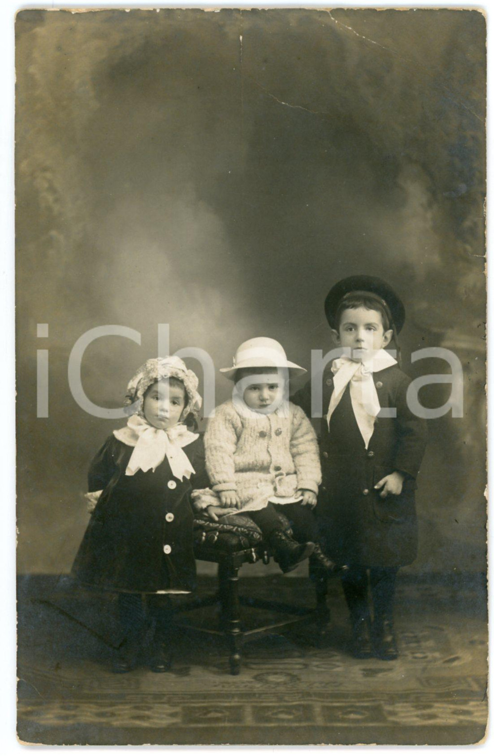 1913 ASTI Ritratto di tre fratellini - Foto cartolina G. BENZI 9x14 cm Fotografia originale d'epoca, in formato cartolina postale, con messaggio manoscritto al verso.I bambini ritratti sono identificati come Santino, Anna Maria e Clelio.CONDIZIONI: P (piegature al lato superiore; fioriture al verso)FORMATO: 9x14 cm    originale e autentica 1