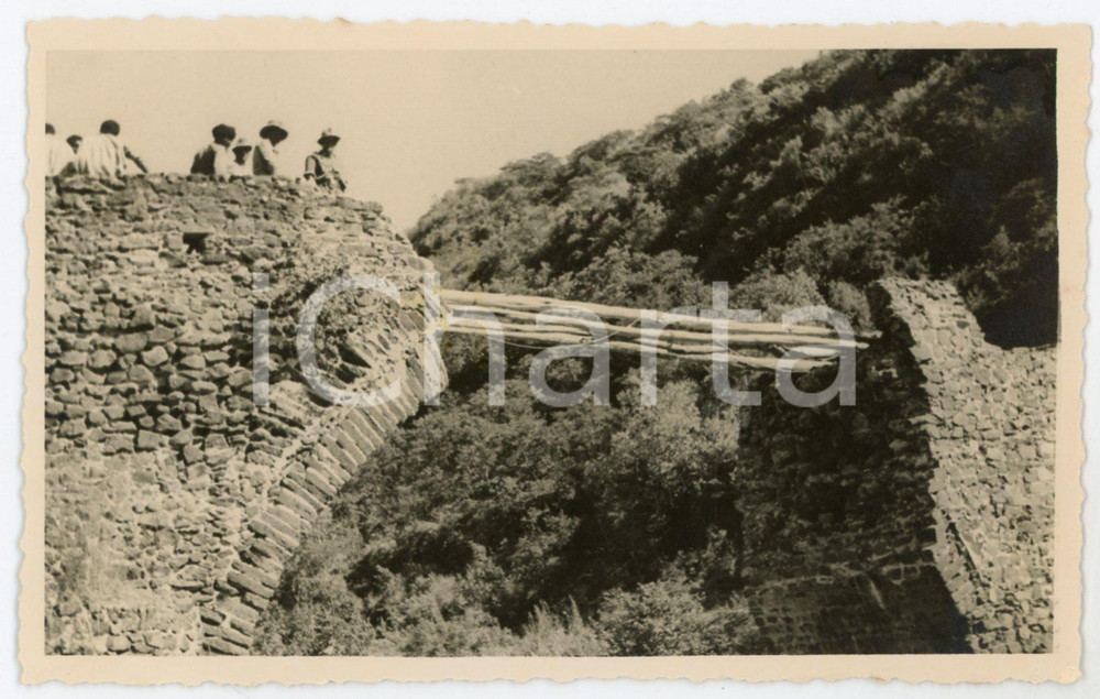 1935 ca AFRICA ORIENTALE ITALIANA Ufficiali presso ponte distrutto *Foto 9x14 Fotografia originale d'epoca, che mostra un gruppo di militari coloniali italiani presso un ponte distrutto, con passerella provvisoria costituita da tronchi.CONDIZIONI: P (residuo centrale di colla)FORMATO: 14x9 cm    originale e autentica 1