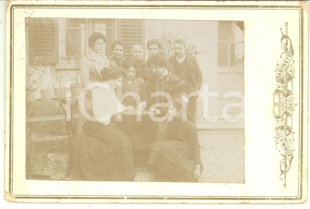 1900 ca COSTUME LOMBARDIA (?) Famiglia gioca a dama in cortile - Foto CURIOSA Fotografia d'epoca, montata su cartoncino rigido.CONDIZIONI: F (minime abrasioni e piegature al cartoncino)FORMATO: 16x11 cm    originale e autentica 1