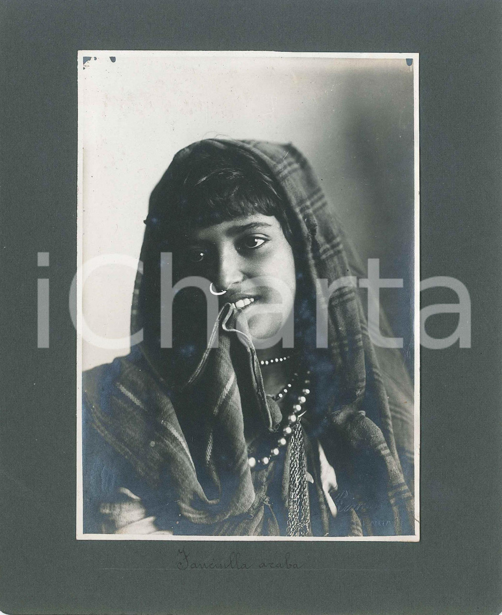 1920 BENGASI (LIBIA ITALIANA) Fanciulla araba - Foto C. RIMOLDI 18x22 cm Fotografia originale d'epoca, montata su cartoncino morbido.Al verso &egrave; presente una seconda fotografia, con didascalia "Piccolo portatore con la coffa".FOTOGRAFO: C. Rimoldi - BengasiCONDIZIONI: G FORMATO: 18x22 cm    originale e autentica 1
