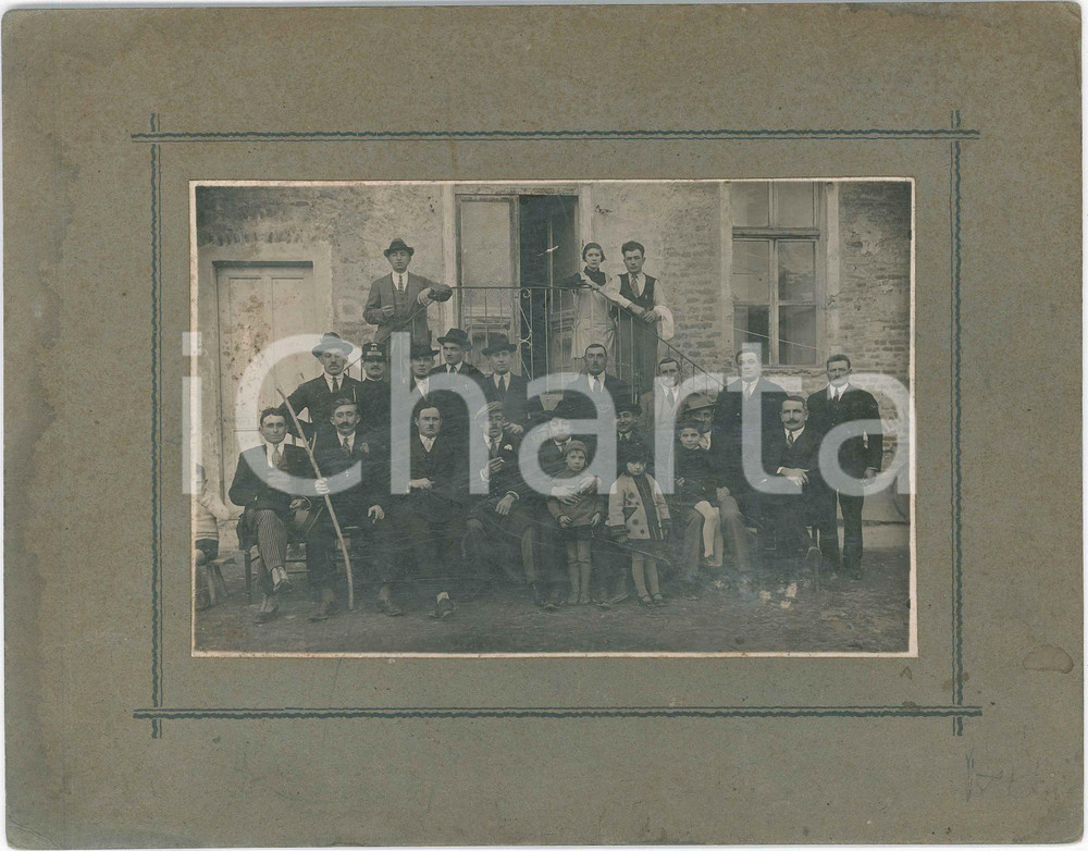 1910 ca s. l. COSTUME Ritratto di gruppo in un cortile - Fotografia 26x20 cm Fotografia originale d'epoca, montata su cartoncino rigido. POOR/danneggiato graffi superficiali; lievi macchie Formato: 26x20 cm originale e autentica 1