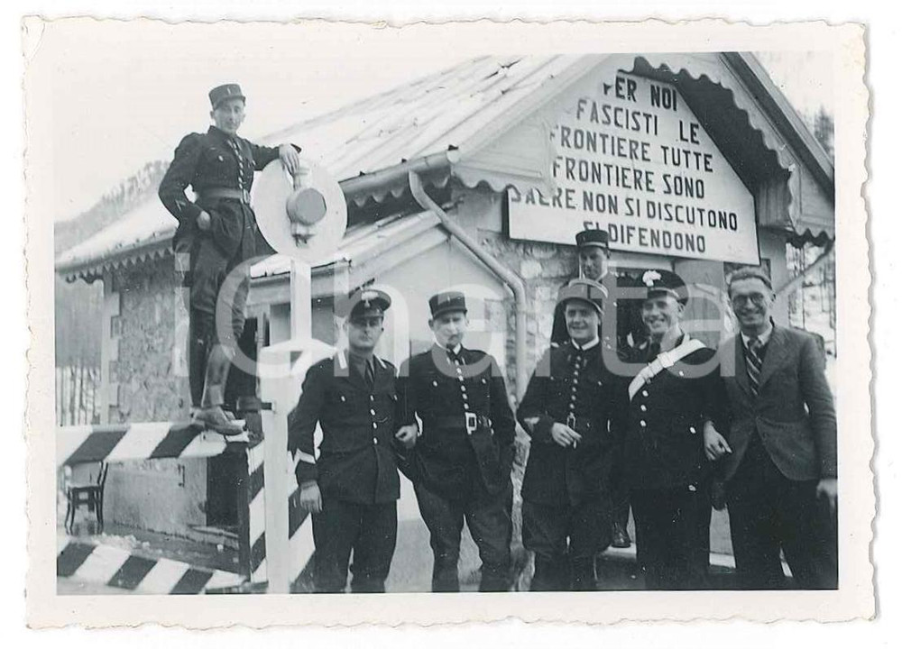 1940 ca ITALIA Dogana con motto "Le frontiere sono sacre"- Foto ANIMATA 9x6 cm  Fotografia d'epoca, che mostra un gruppo di militari e personale di una dogana non identificata, con motto "Per noi fascisti le frontiere, tutte le frontiere, sono sacre. Non si discutono, si difendono". GOOD/buono minima piegatura angolare Formato: 9x6 cm originale e autentica 1
