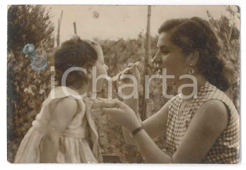 1940 ca ITALIA Mamma imbocca la figlia - Fotografia anonima 9x6 cm  Fotografia d'epoca. POOR/danneggiato Lievi smussature agli angoli, macchia al recto Formato: 9x6 cm originale e autentica 1