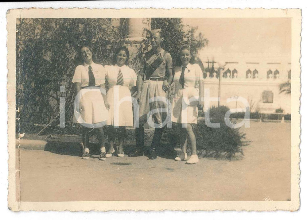 1941 ca GIL ITALIA - COLONIE - Giovani italiane con istruttore - Foto 12x8 cm  Fotografia d'epoca, con didascalia manoscritta al verso. POOR/danneggiato piegatura verticale al lato sinistro Formato: 12x8 cm originale e autentica 1