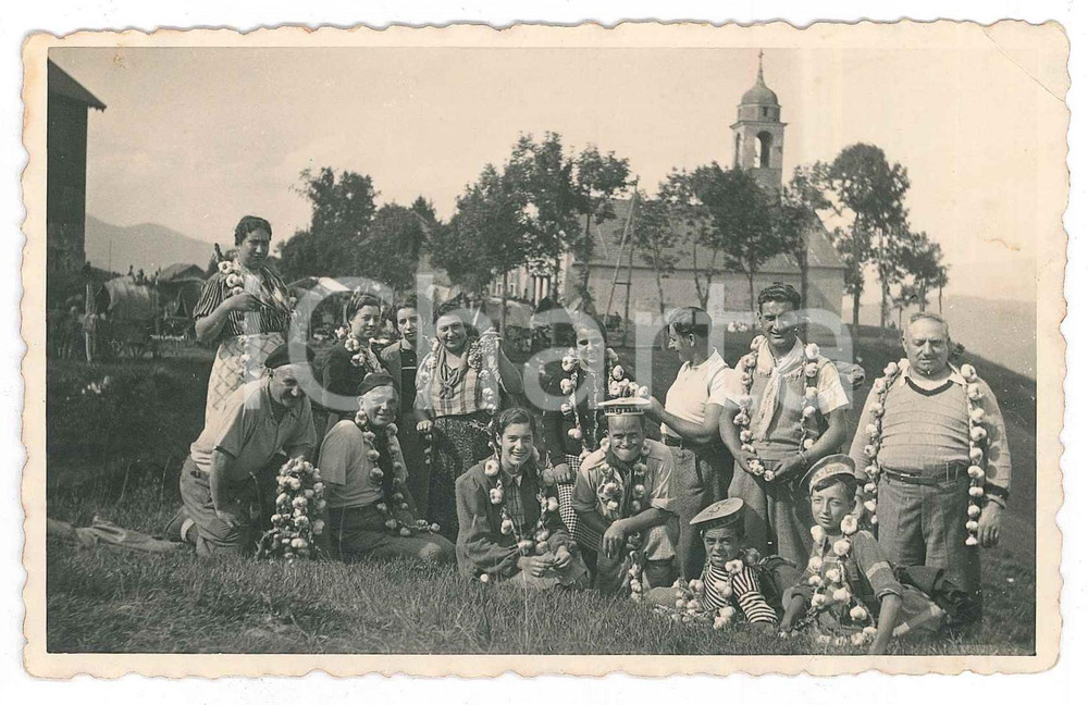 1950 ca s. l. ITALIA Campagna - Foto di gruppo con collane d'aglio *Foto CURIOSA  Fotografia d'epoca, in formato cartolina postale. POOR/danneggiato piegatura all'angolo superiore destro e graffio al lato superiore; fioriture al verso Formato: 14x9 cm originale e autentica 1