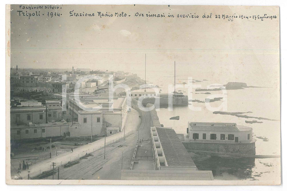 1914 TRIPOLI (LIBIA ITALIANA) Stazione Radio Molo - Fotografia 17x10,5 cm Fotografia d'epoca, con didascalia manoscritta al recto.FOTOGRAFO: Silvio Fachinotti POOR/danneggiato minimi strappi ai margini, lievi abrasioni, macchie e piegature; vasto residuo cartaceo e di colla al verso Formato: 17x10,5 cm originale e autentica 1