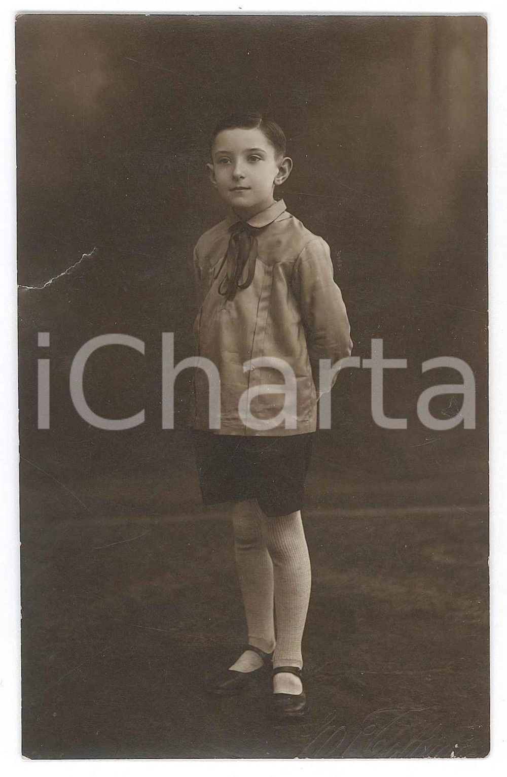 1930 ca ITALIA Scolaro in grembiule il primo giorno di scuola Fotografia anonima  Fotografia d'epoca in formato cartolina postale. VERY POOR/gravemente danneggiato Lievi smussature agli angoli, profondo strappo al margine sinistro Formato: 8x13 originale e autentica 1