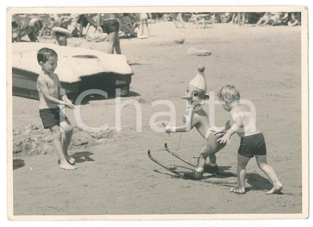 1950 ca RIVIERA ROMAGNOLA Bambini giocano con pupazzo di PINOCCHIO Foto anonima  Fotografia d'epoca.FOTOGRAFO: Foto Umberto - Meldola FAIR/discreto Lievi smussature e piegature agli angoli Formato: 14x10 originale e autentica 1
