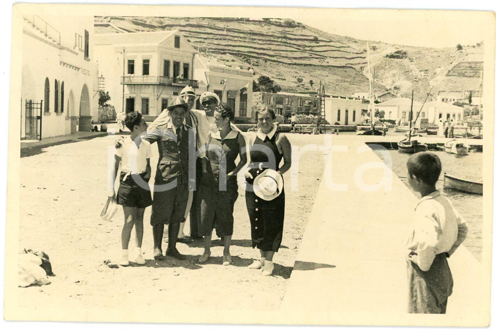 1940 ca GRECIA ? Gruppo di amici al porto - Coppia nuda al verso - Foto CURIOSA Fotografia d'epoca, che reca al verso, incollata, una piccola foto con una coppia nuda abbracciata, di schiena.Didascalia dattiloscritta "C. Del Baro".FOTOGRAFO: Vasari - Roma GOOD/buono  Formato: 15x10 cm originale e autentica 1