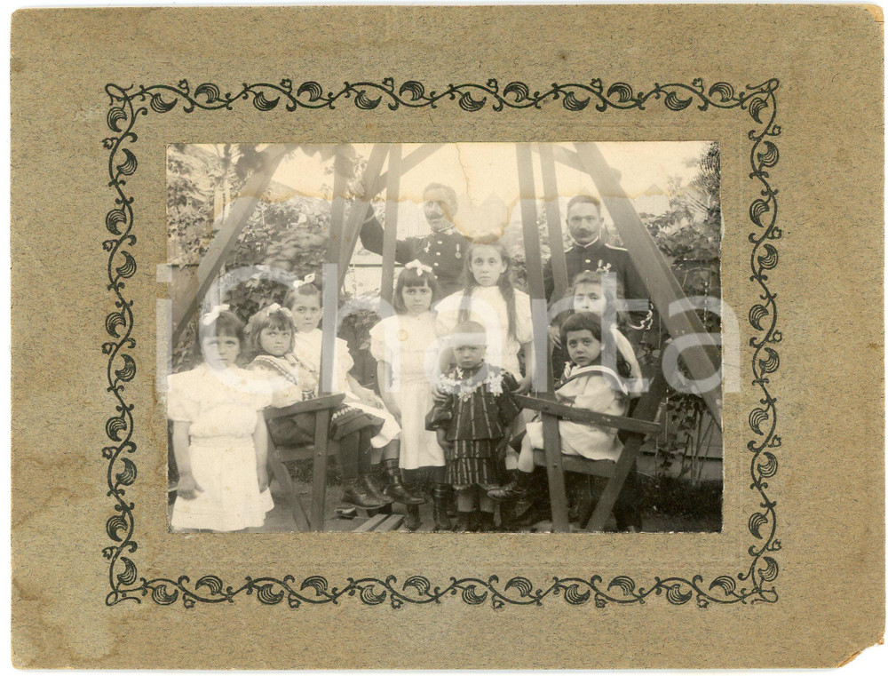 1900 ca ITALIA Ufficiali in giardino con gruppo di bambine - Foto DANNEGGIATA Fotografia d'epoca, montata su cartoncino. VERY POOR/gravemente danneggiato piccola mancanza angolare; piegature evidenti; macchie di umidità Formato: 18x14 cm originale e autentica 1