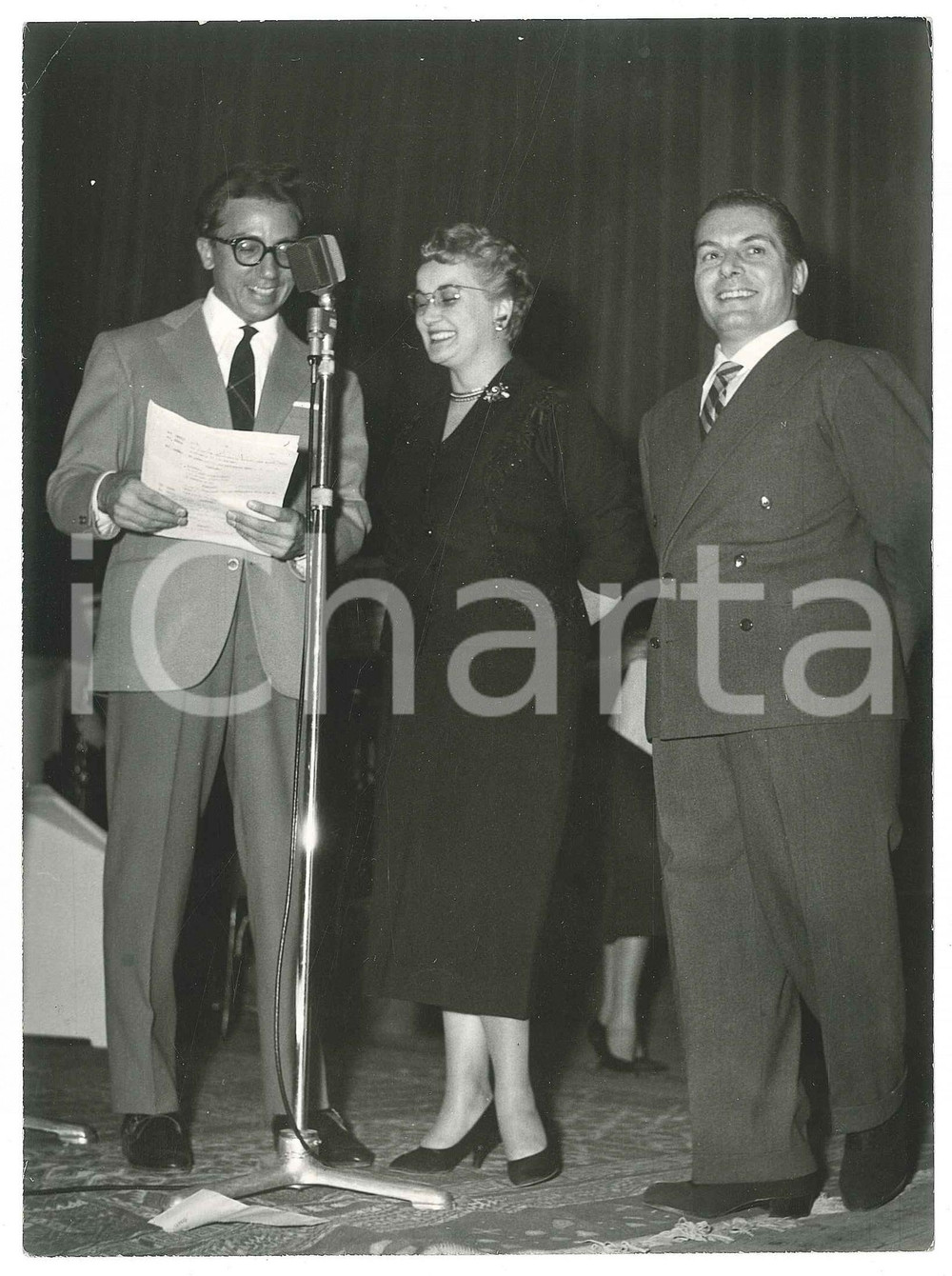 1957 MILANO (?) Mike BONGIORNO presenta una serata - Foto 13x18  Fotografia d'epoca, con timbro datario al verso.FOTOGRAFO: Andrea Alaino - Bellusco   FAIR/discreto piccola piegatura angolare Formato: 13x18 cm originale e autentica 1