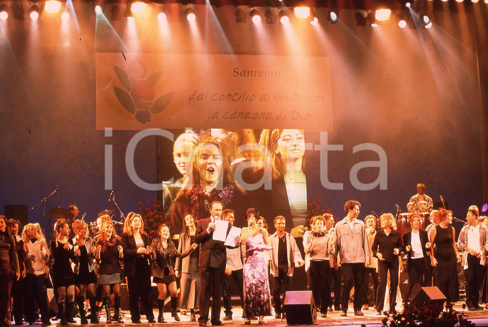 35mm vintage slide* 1999 GRANDE MEETING SANREMO Ettore ANDENNA e MARIADELE (3)  Diapositiva d'epoca, in formato 35 mm.CONDIZIONI: GOODNella diapositiva compaiono i componenti del guppo vocale Emmanuel.E' severamente vietata la riproduzione. Tutti i diritti sono riservati.Nella diapositiva ICharta mette in vendita, sul negozio eBay e in esclusiva sul sito "icharta" il proprio archivio composto da numerose diapositive e negativi fotografici d'epoca, tutti originali e autentici, che attraversano la storia del costume italiano tra gli la fine degli anni Sessanta e Novanta.Si tratta di uno sguardo inedito sull'attualit&agrave;, la politica, la vita quotidiana, il gossip e la cultura, che fotografa il cambiamento della nazione in quest'ultimo scorcio del XX secolo. Un'occasione unica per il mercato del collezionismo, che vede finalmente disponibile un archivio eccezionale per vastit&agrave;, tematiche e condizioni, in un settore (il negativo fotografico e la diapositiva) di assoluta novit&agrave; e dalle interessanti prospettive di investimento. GOOD/buono   originale e autentica 1