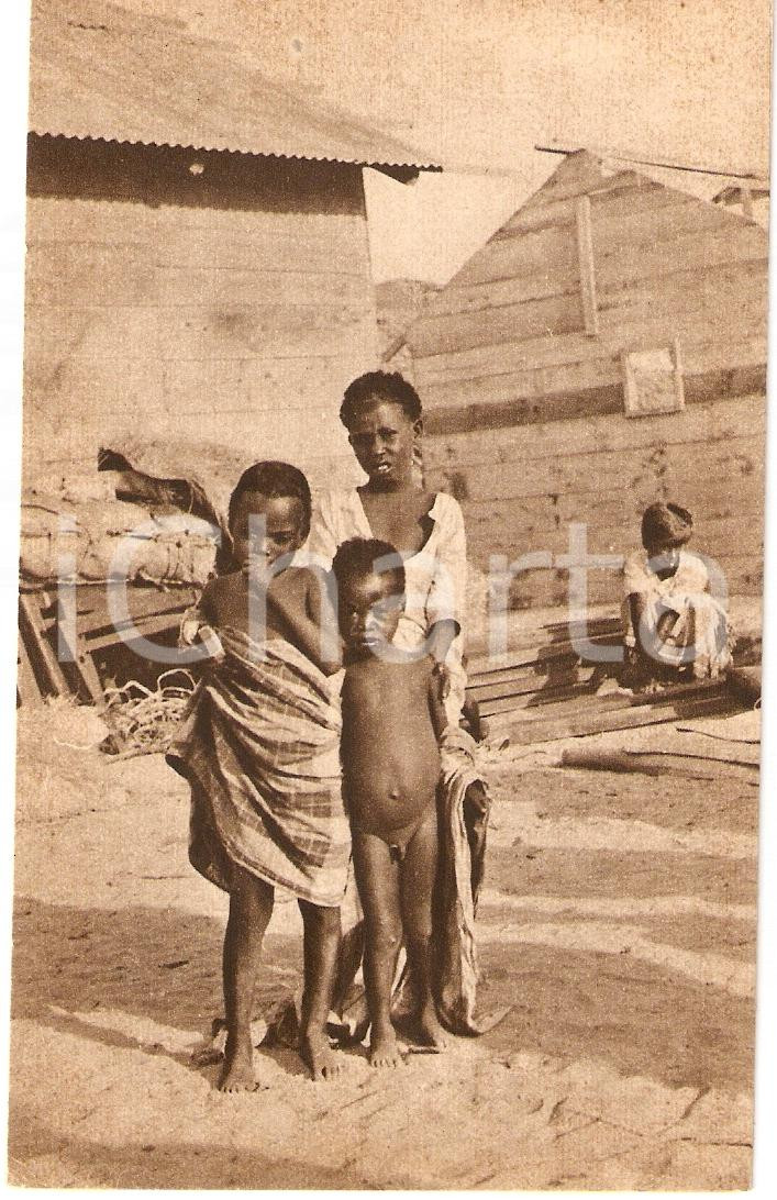Cartolina originale da collezione 1930 ca ERITREA A.O.I. Ragazzini indigeni con casa in costruzione Cartolina FG 1