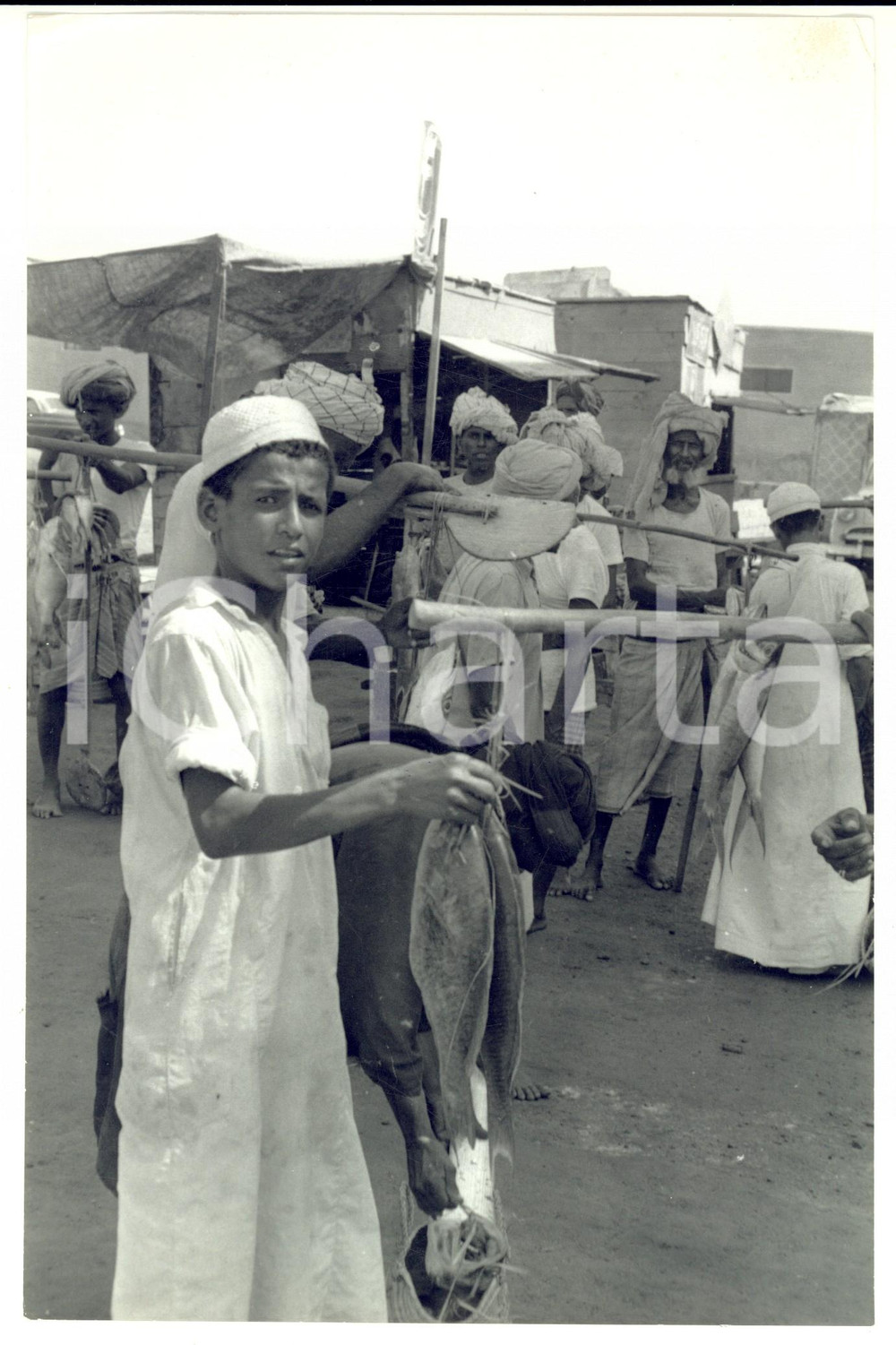 Fotografia d epoca originale 1960 ca OMAN Bambino vende due pesci al mercato Fotografia ARTISTICA 1