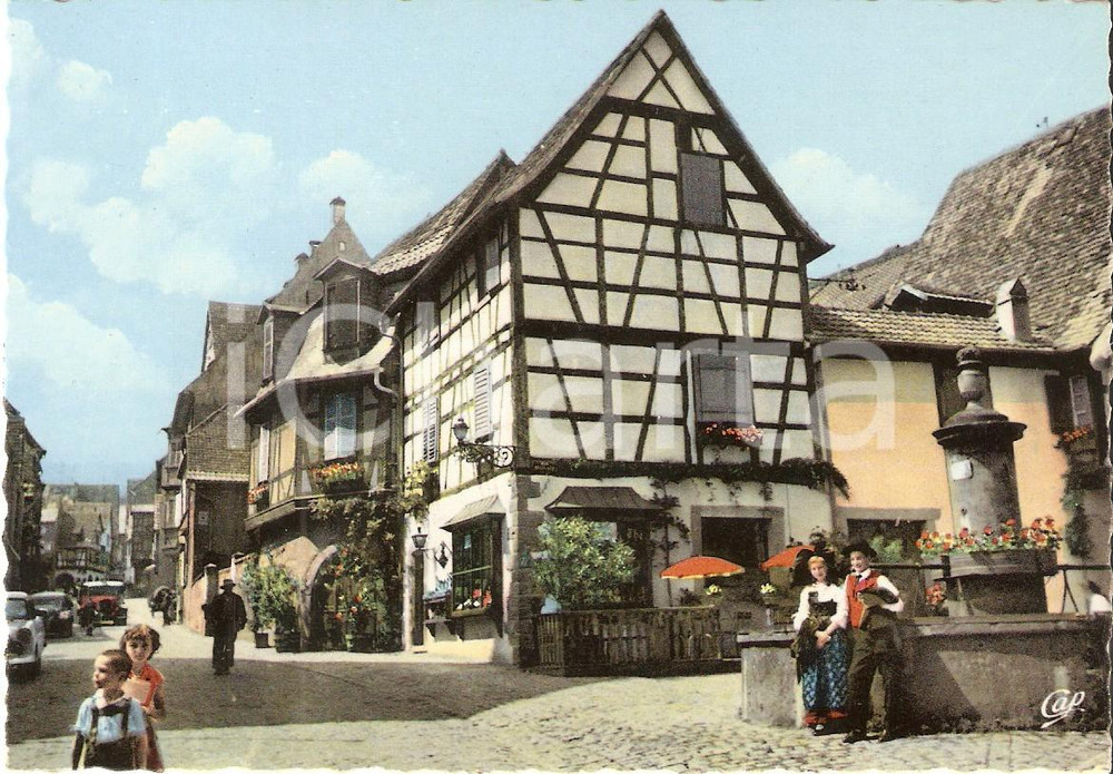 Cartolina originale da collezione 1970 ca RIQUEWIHR FRANCE Fontana e abitanti con costumi tipici Cartolina FG NV 1