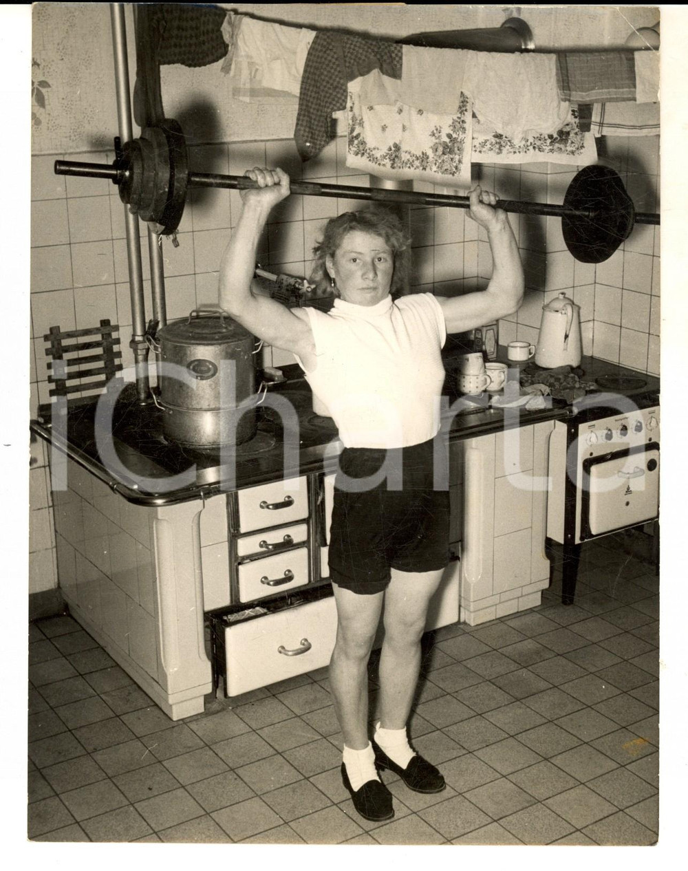 Fotografia d epoca originale 1955 ca GERMANIA SOLLEVAMENTO PESI DONNE Atleta si allena nella cucina di casa 1