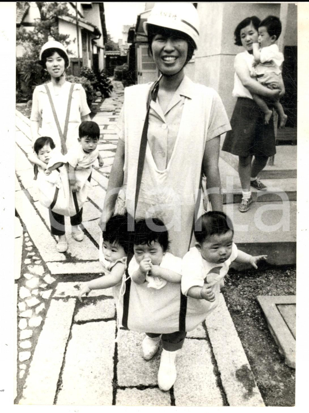 1970 JAPAN Infermiera con un sacco-canguro per la sicurezza dei bambini *Foto