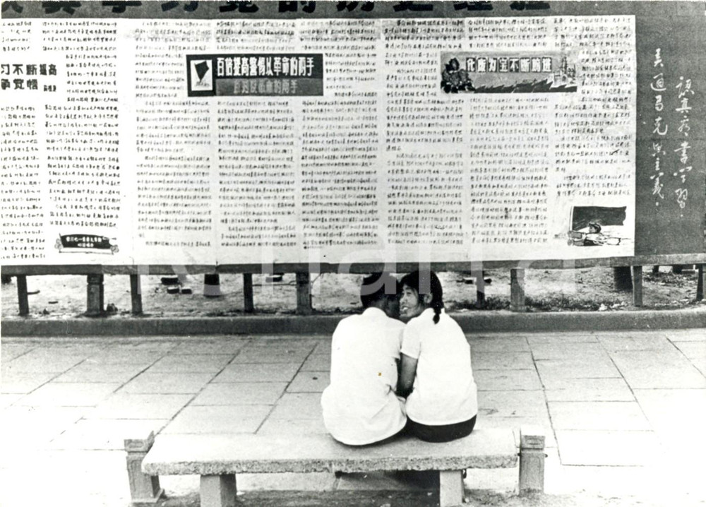 Fotografia d epoca originale 1973 PECHINO CHINA  Due giovani innamorati seduti davanti a giornale murale 1