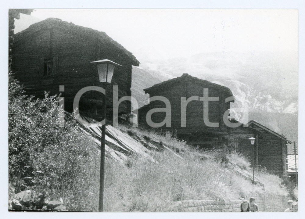 1980 SAAS-FEE (SVIZZERA) Panorama con baite in legno - Foto 17x13 cm Fotografia d'epoca con didascalia al verso.  FAIR/discreto Lievi smussature agli angoli Formato: 17x13 cm originale e autentica 1