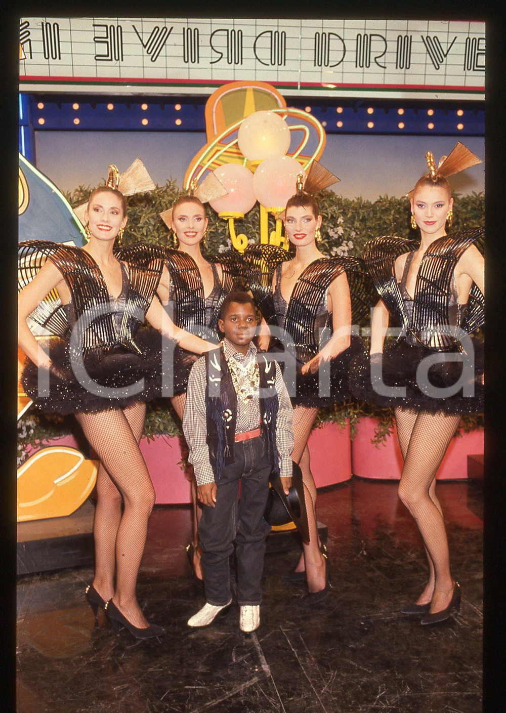 35mm vintage slide* 1985ca DRIVE IN Italia 1 GARY COLEMAN e ragazze BOMBERS   Diapositiva d'epoca, in formato 35 mm. CONDIZIONI: GOODTutti i diritti riservati.E' severamente vietata la riproduzione. ICharta mette in vendita, sul negozio eBay e in esclusiva sul sito "icharta" il proprio archivio composto da numerose diapositive e negativi fotografici d'epoca, tutti originali e autentici, che attraversano la storia del costume italiano tra gli la fine degli anni Sessanta e Novanta.Si tratta di uno sguardo inedito sull'attualità, la politica, la vita quotidiana, il gossip e la cultura, che fotografa il cambiamento della nazione in quest'ultimo scorcio del XX secolo. Un'occasione unica per il mercato del collezionismo, che vede finalmente disponibile un archivio eccezionale per vastità, tematiche e condizioni, in un settore (il negativo fotografico e la diapositiva) di assoluta novità e dalle interessanti prospettive di investimento.  originale e autentica 1