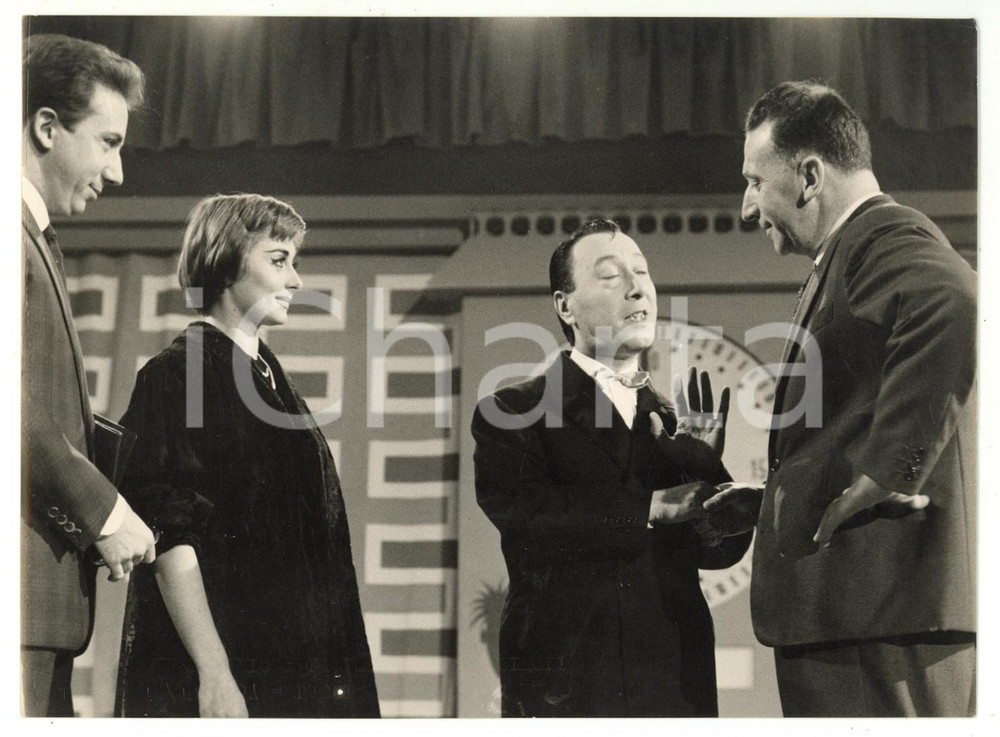 1957 MILANO Lascia o raddoppia? - Erminio MACARIO Sandra MONDAINI Mike BONGIORNO Fotografia d'epoca, con didascalia coeva al verso. CONDIZIONI: FAIR (sovraimpressione lungo il margine inferiore; minima piegatura al centro)FORMATO: 18x13 cm    originale e autentica 1