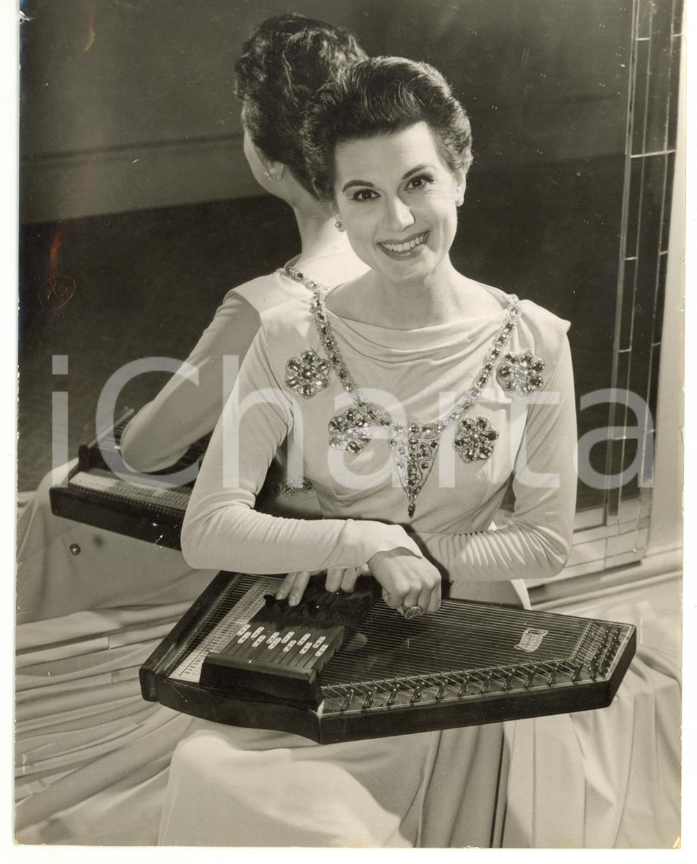 1956 LONDON Doretta MORROW playing the zither *Photo 15x20 Fotografia d'epoca, con didascalia coeva al verso. CONDIZIONI: FAIR (piccole piegature; strappo millimetrico al margine sinistro)FORMATO: 15x20 cm    originale e autentica 1