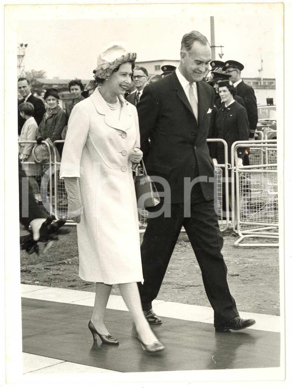 1961 LONDON AIRPORT - ELIZABETH II and Duke of EDINBURGH leaving for SARDINIA Fotografia d'epoca, con didascalia coeva al verso. CONDIZIONI: POOR (lieve piegatura e piccoli aloni al margine superiore; piegatura al centro)FORMATO: 15x20 cm     originale e autentica 1
