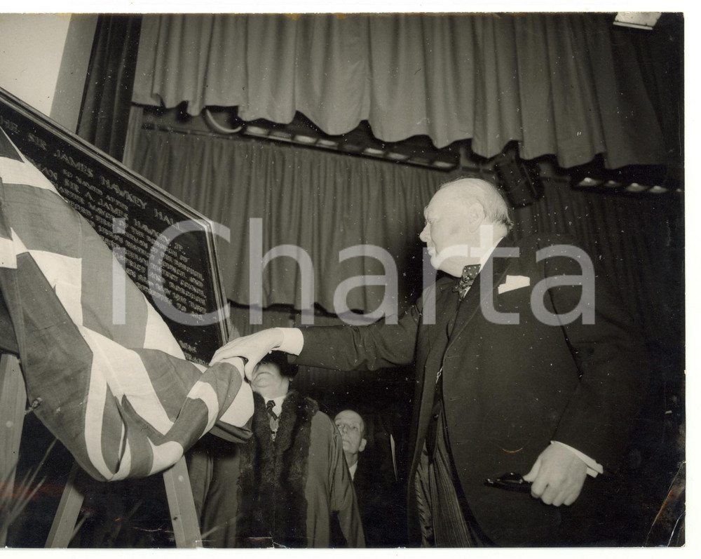 1955 LONDON WOODFORD Winston CHURCHILL unveiling memorial plaque of James HAWKEY Fotografia d'epoca, con didascalia coeva al verso.  CONDIZIONI: POOR (piccola piegatura all'angolo inferiore destro; piccole macchie; strappo millimetrico al margine inferiore sovraimpressione) CONDIZIONI: 20x15 cm    originale e autentica 1