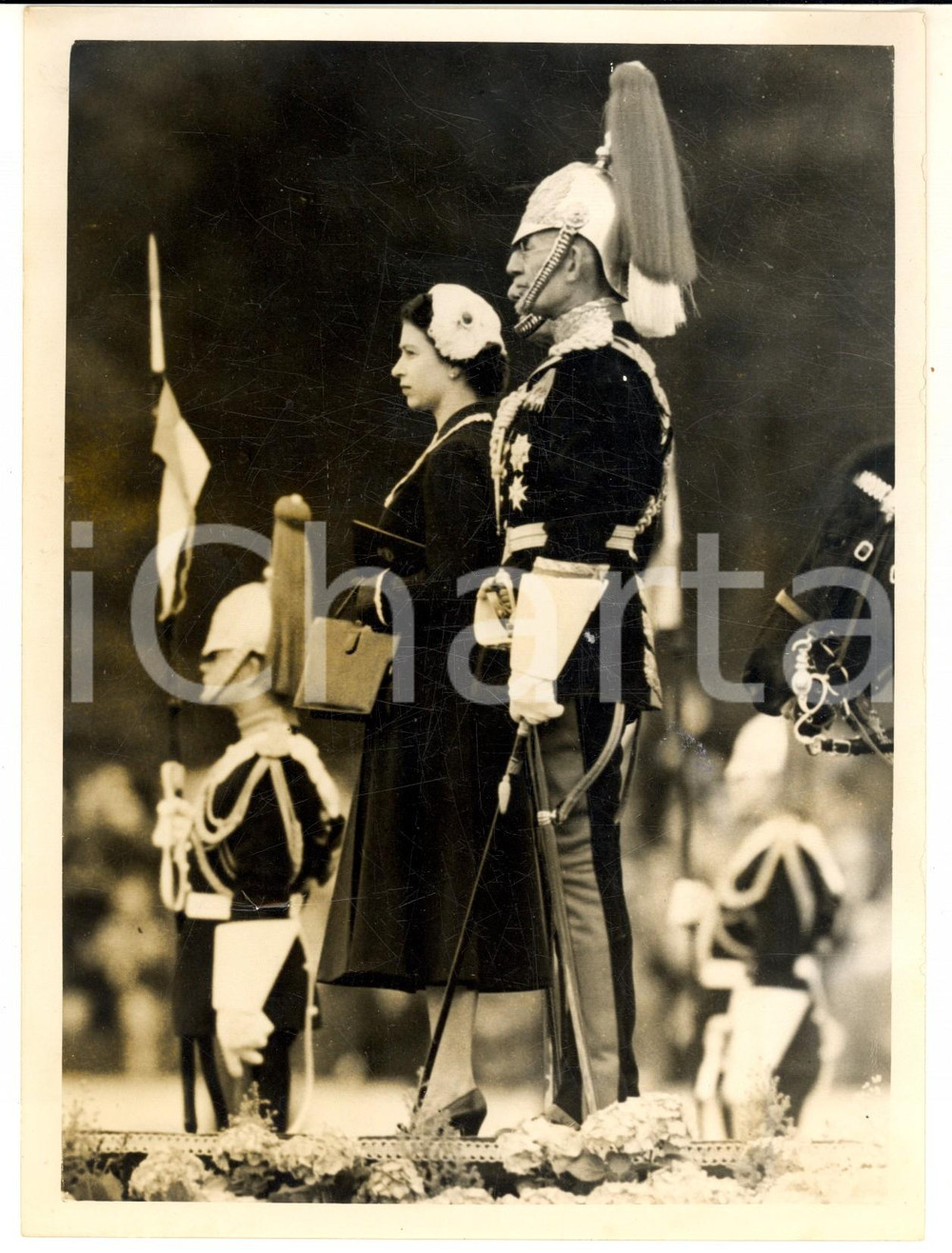 1954 LONDON Regina Elisabetta II durante una cerimonia militare - Foto 15x20 cm Fotografia d'epoca con didascalia coeva al verso.  CONDIZIONI: FAIR (piegatura al margine inferiore e lieve sovraimpressione) FORMATO: 15x20 cm     originale e autentica 1