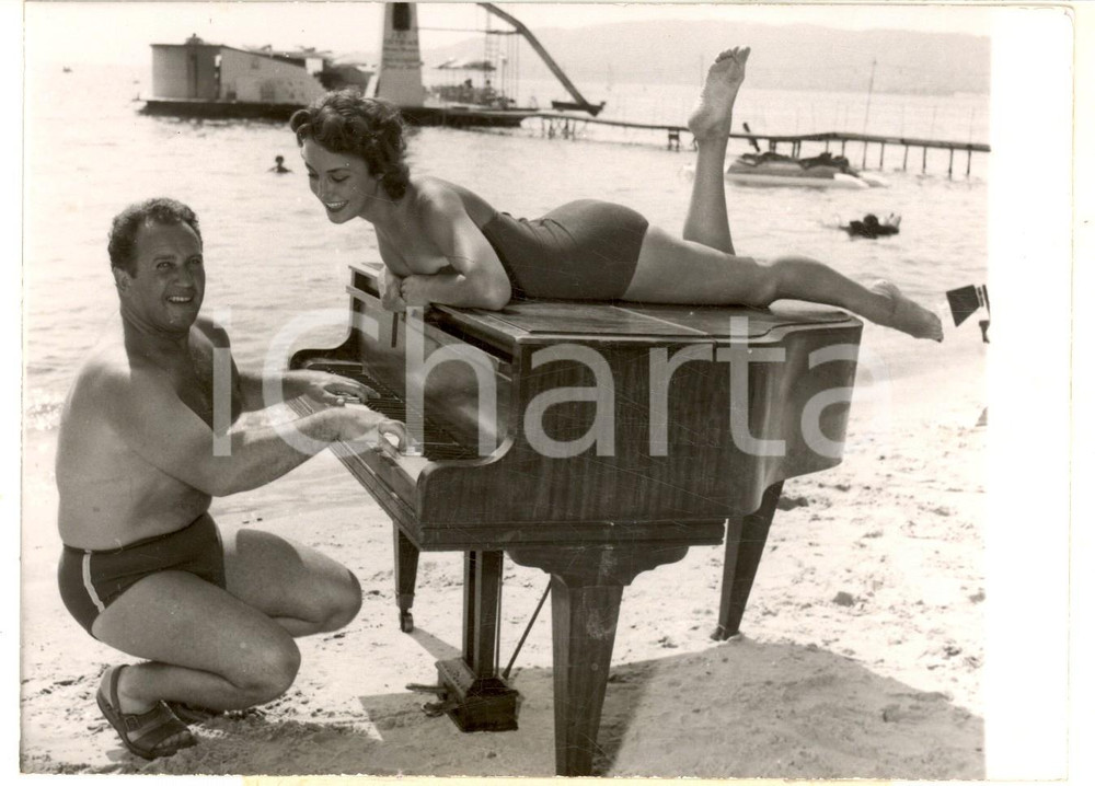 1955 JUAN-LES-PINS Francis LOPEZ con Miss France VÃ©ronique ZUBER sul pianoforte Fotografia d'epoca, con didascalia coeva. CONDIZIONI: FAIR (lievi piegature)FORMATO: 17x12 cm     originale e autentica 1
