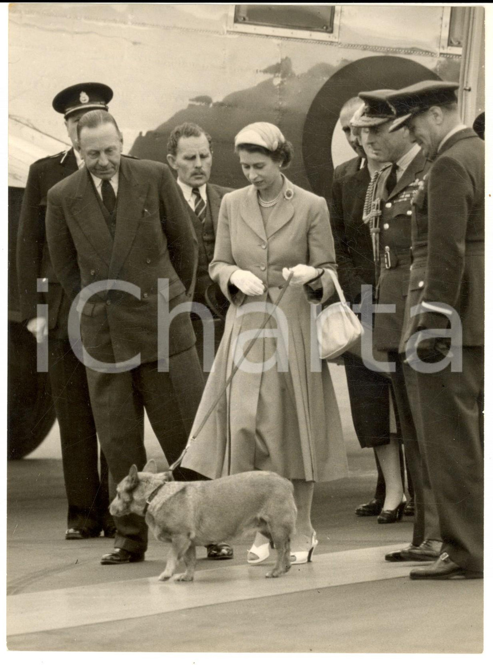 1954 LONDON AIRPORT Queen Elizabeth holds her pet Corgi *Photo 15x20 cm Fotografia d'epoca con didascalia coeva al verso.  CONDIZIONI: G (ma lieve sovraimpressione)FORMATO: 15x20 cm     originale e autentica 1
