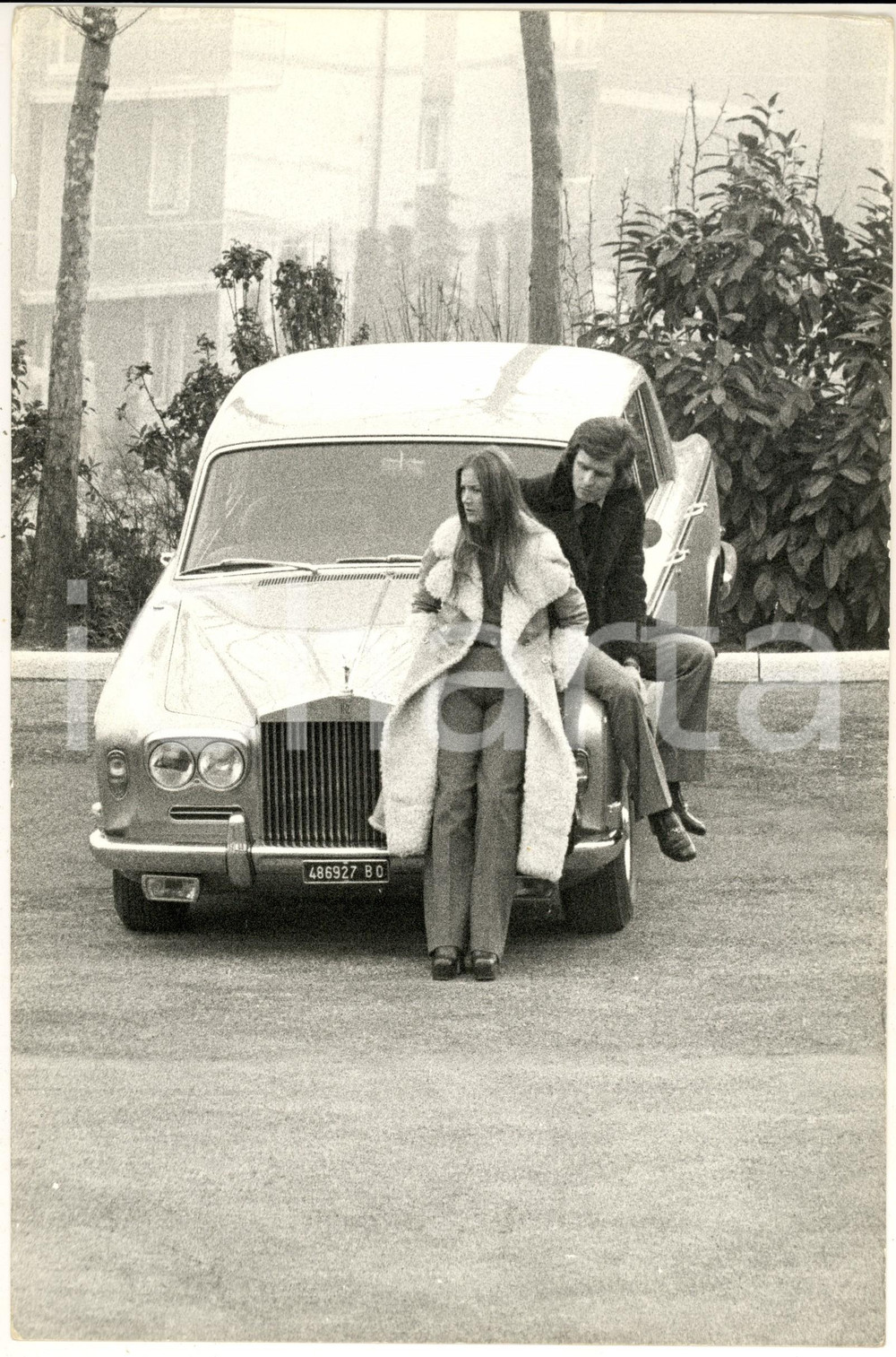 1970 ca GOSSIP ITALIA Barbara BOUCHET su un'auto con Paolo PAZZAGLIA (1) - Foto Fotografia di agenzia. CONDIZIONI: G (ma lieve piegatura angolare)FORMATO: 20x30 cm    originale e autentica 1