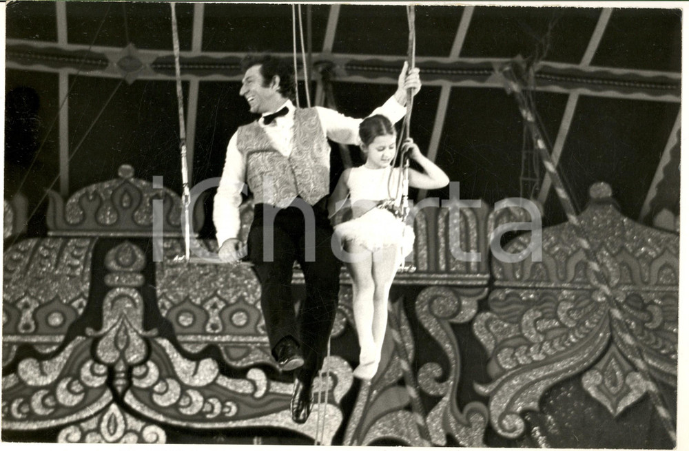 1970 ca ITALIA CIRCO MEDRANO Numero al trapezio con bambina (1) Foto 30x20 cm Fotografia d'epoca. CONDIZIONI: FAIR (margine superiore rozzamente rifilato)FORMATO: 30x20 cm    originale e autentica 1