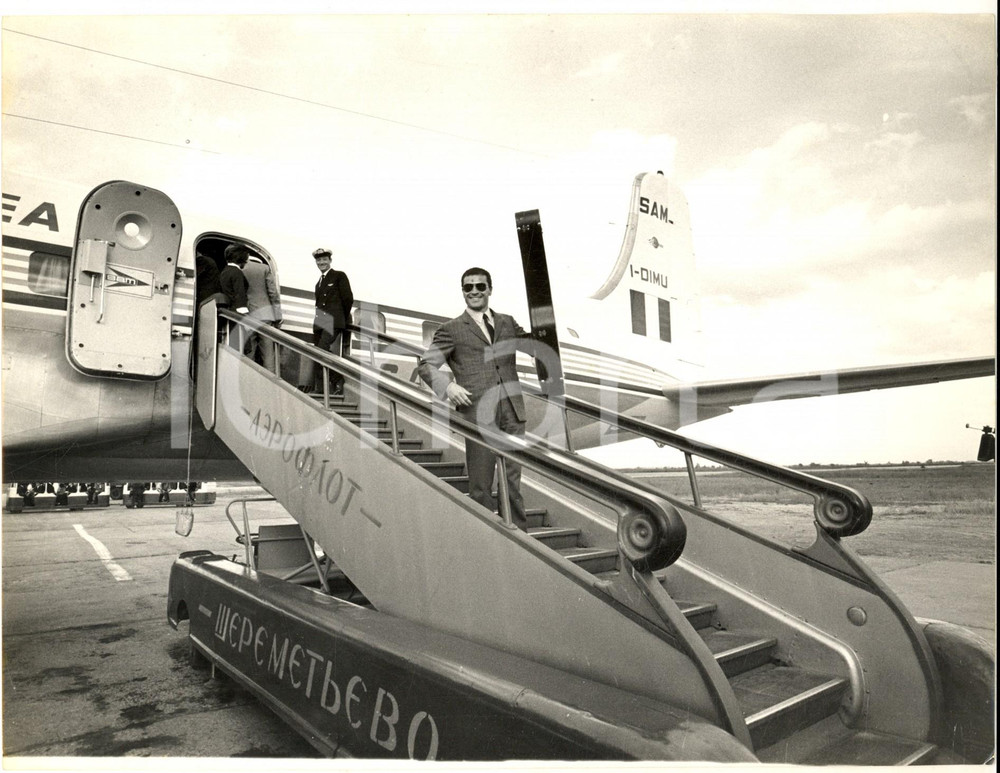1965 CANTAGIRO MOSCA Arrivo di Edoardo VIANELLO su volo AEROFLOT *Foto 24x18 Fotografia d'epoca, con didascalia coeva al verso.  CONDIZIONI: FAIR (piegatura al margine superiore e ondulazione)     originale e autentica 1