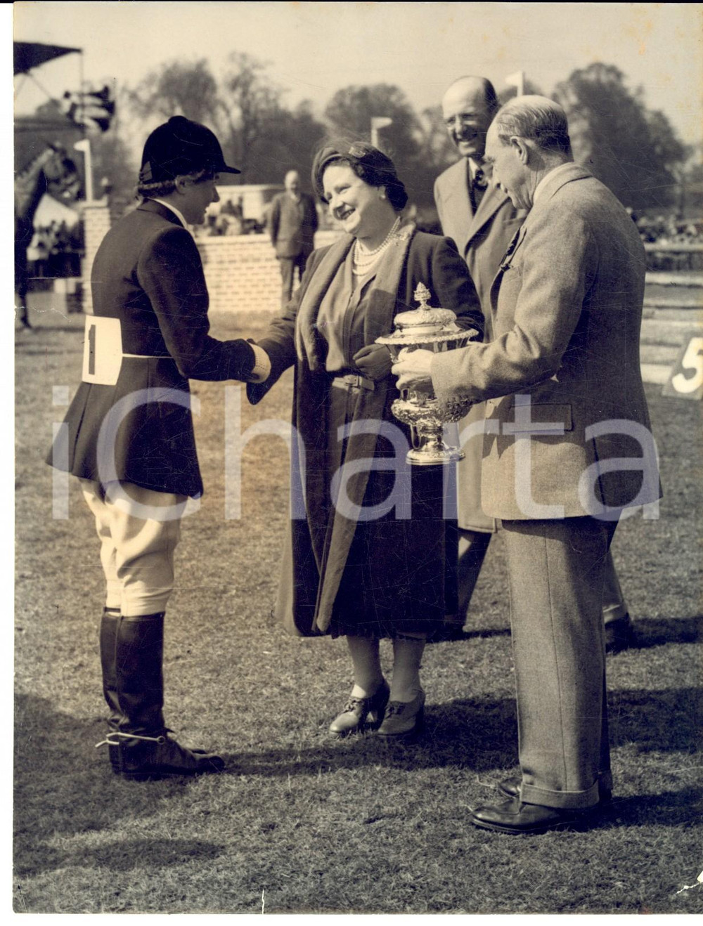 1954 BADMINTON Championship - Queen Mother congratulates winner Margaret HOUGH Fotografia d'epoca con didascalia coeva.  CONDIZIONI: POOR (piegature centrali e alone; minimi strappi marginali) FORMATO: 15x20 cm    originale e autentica 1