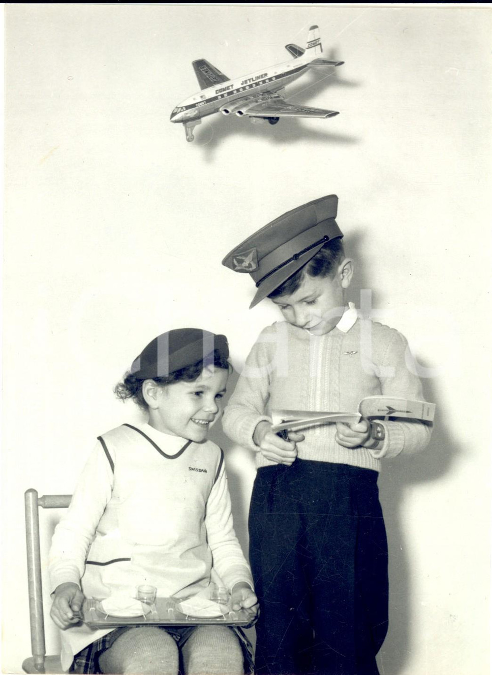 1967 ZURICH Bambini nelle vesti di pilota e hostess SWISSAIR *Foto 13x18 cm Fotografia d'epoca con didascalia coeva. CONDIZIONI: FAIR (piegatura all'angolo inferiore sinistro)FORMATO:  13x18 cm     originale e autentica 1