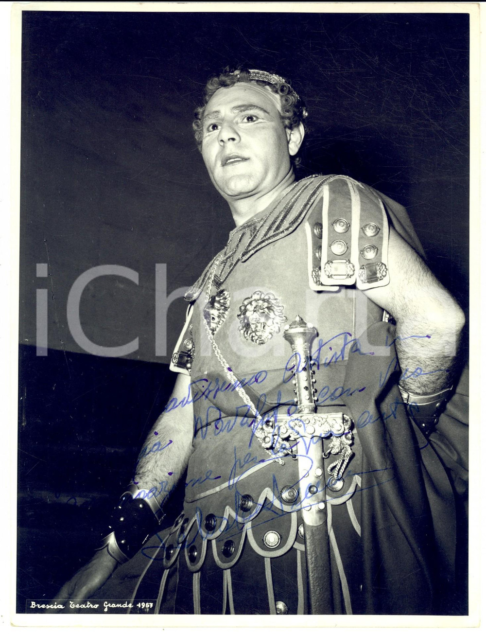 1957 BRESCIA Teatro Grande - Tenore Salvatore PUMA - Foto con autografo 18x24 cm  Fotografia d'epoca con autografo, scattata in occasione della rappresentazione della "Norma".CONDIZIONI: POOR (lieve piegatura angolare, con mancanza al verso; residui cartacei e abrasioni al verso)    originale e autentica 1