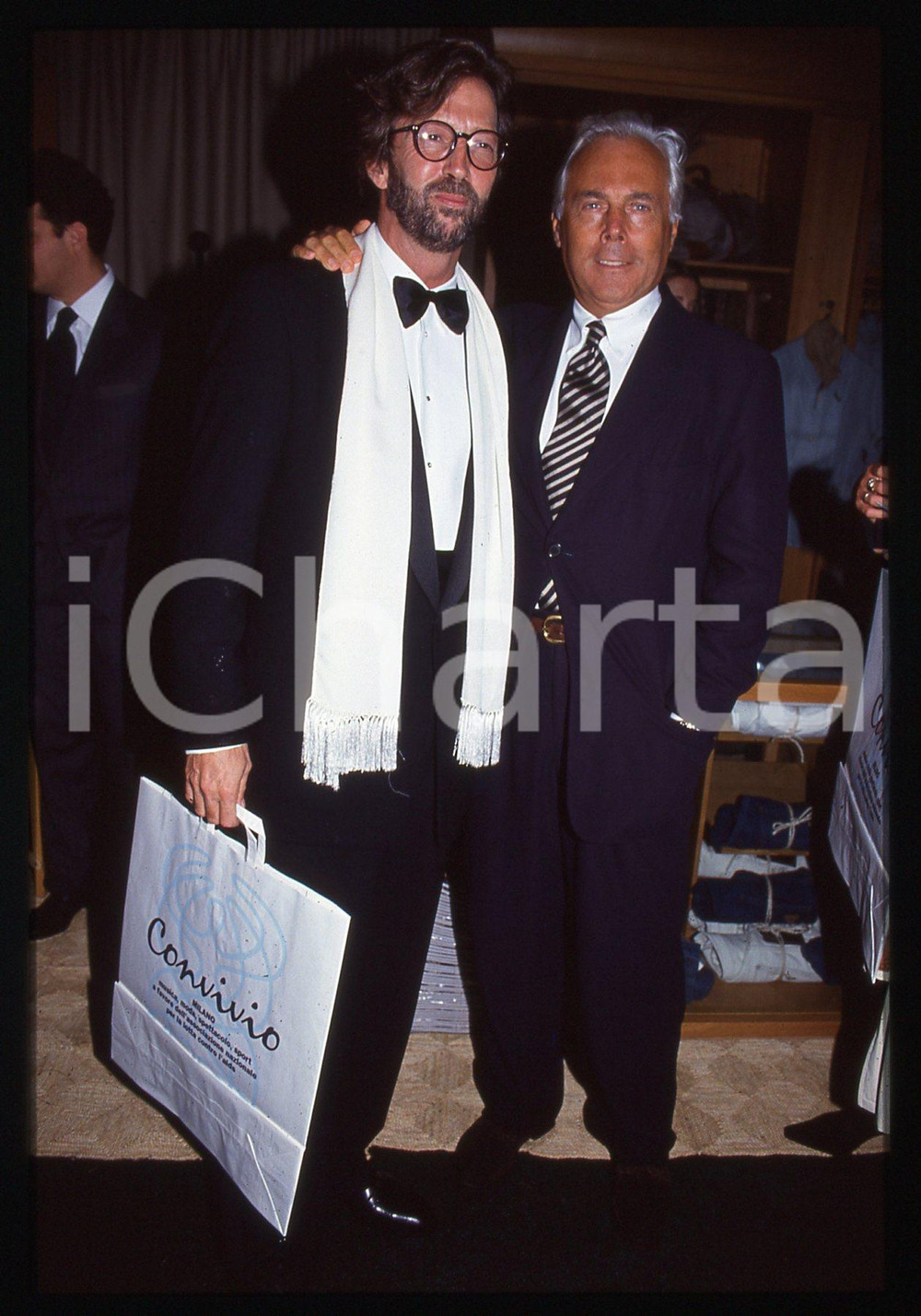 Giorgio ARMANI Eric CLAPTON - MILANO 1992 CONVIVIO * 35 mm vintage slide 5  Diapositiva d'epoca, in formato 35 mm.Si trattava di Convivio, evento benefico per la lotta all'AIDS tenutosi a Milano nel 1992. Per i diritti rivolgersi a ICharta.E' severamente vietata la riproduzione. Tutti i diritti sono riservati.Nella diapositiva ICharta mette in vendita, sul negozio eBay e in esclusiva sul sito "icharta" il proprio archivio composto da numerose diapositive e negativi fotografici d'epoca, tutti originali e autentici, che attraversano la storia del costume italiano tra gli la fine degli anni Sessanta e Novanta.Si tratta di uno sguardo inedito sull'attualit&agrave;, la politica, la vita quotidiana, il gossip e la cultura, che fotografa il cambiamento della nazione in quest'ultimo scorcio del XX secolo. Un'occasione unica per il mercato del collezionismo, che vede finalmente disponibile un archivio eccezionale per vastit&agrave;, tematiche e condizioni, in un settore (il negativo fotografico e la diapositiva) di assoluta novit&agrave; e dalle interessanti prospettive di investimento.  GOOD/buono   originale e autentica 1