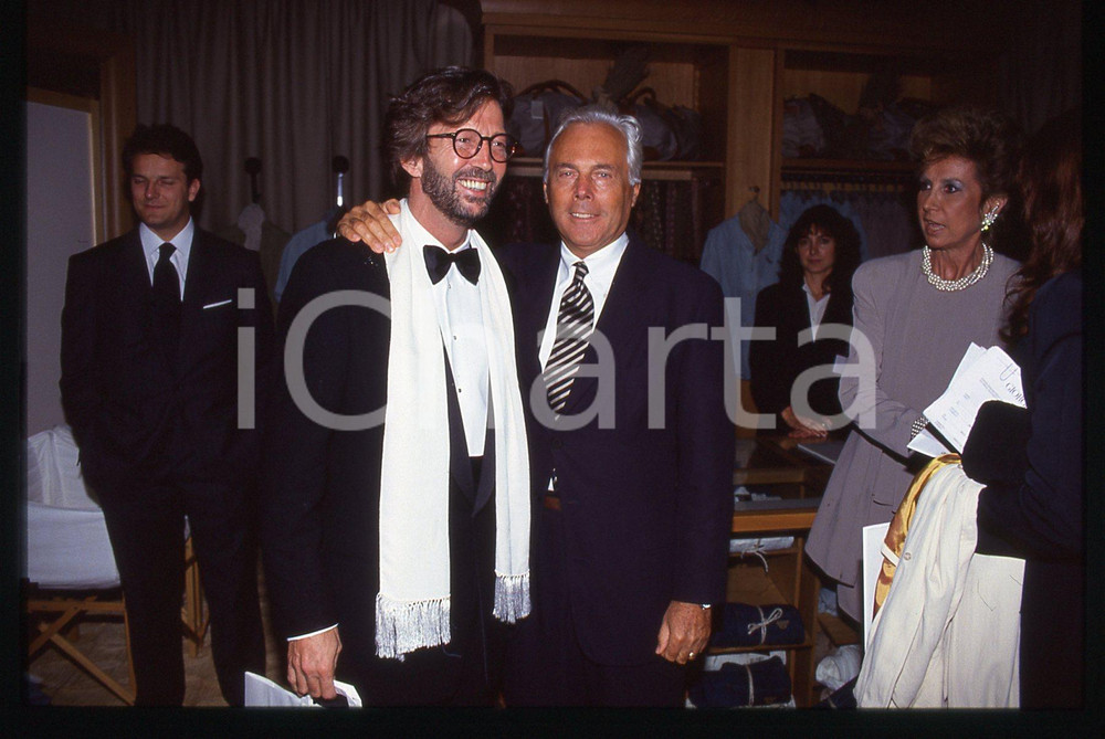 Giorgio ARMANI Eric CLAPTON - MILANO 1992 CONVIVIO * 35 mm vintage slide 7  Diapositiva d'epoca, in formato 35 mm.Si trattava di Convivio, evento benefico per la lotta all'AIDS tenutosi a Milano nel 1992. Per i diritti rivolgersi a ICharta.E' severamente vietata la riproduzione. Tutti i diritti sono riservati.Nella diapositiva ICharta mette in vendita, sul negozio eBay e in esclusiva sul sito "icharta" il proprio archivio composto da numerose diapositive e negativi fotografici d'epoca, tutti originali e autentici, che attraversano la storia del costume italiano tra gli la fine degli anni Sessanta e Novanta.Si tratta di uno sguardo inedito sull'attualit&agrave;, la politica, la vita quotidiana, il gossip e la cultura, che fotografa il cambiamento della nazione in quest'ultimo scorcio del XX secolo. Un'occasione unica per il mercato del collezionismo, che vede finalmente disponibile un archivio eccezionale per vastit&agrave;, tematiche e condizioni, in un settore (il negativo fotografico e la diapositiva) di assoluta novit&agrave; e dalle interessanti prospettive di investimento.  GOOD/buono   originale e autentica 1