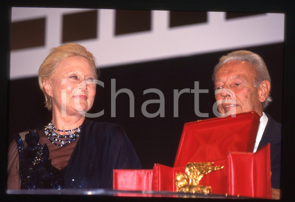 35mm vintage slide* 1996 VENEZIA Michèle MORGAN Gian Luigi RONDI - LEONE D'ORO 2 La diapositiva &egrave; stata scattata in occasione della Mostra del Cinema e compare Gian Luigi RondiDiapositiva d'epoca, in formato 35 mm. CONDIZIONI: GOODE' severamente vietata la riproduzione. Tutti i diritti sono riservati. ICharta mette in vendita, sul negozio eBay e in esclusiva sul sito "icharta" il proprio archivio composto da numerose diapositive e negativi fotografici d'epoca, tutti originali e autentici, che attraversano la storia del costume italiano tra gli la fine degli anni Sessanta e Novanta.Si tratta di uno sguardo inedito sull'attualit&agrave;, la politica, la vita quotidiana, il gossip e la cultura, che fotografa il cambiamento della nazione in quest'ultimo scorcio del XX secolo. Un'occasione unica per il mercato del collezionismo, che vede finalmente disponibile un archivio eccezionale per vastit&agrave;, tematiche e condizioni, in un settore (il negativo fotografico e la diapositiva) di assoluta novit&agrave; e dalle interessanti prospettive di investimento.  originale e autentica 1