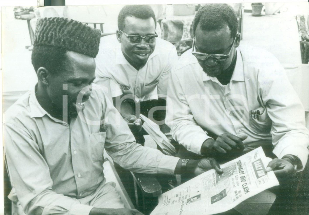 Fotografia d epoca originale 1965 DAR ES SALAAM Ribelle Gaston SOUMIALOT legge la notizia della propria morte 1