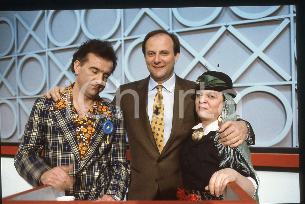 35mm vintage slide* 1990ca CANALE 5 Gerry SCOTTI Gene GNOCCHI Emilietta FARINA 1  Diapositiva d'epoca, in formato 35 mm. Nella diapositiva compaiono Gerry Scotti, Gene Gnocchi ed Emilietta Farina, durante la trasmissione "Il gioco dei 9", in onda su Canale 5.CONDIZIONI: GOOD Tutti i diritti riservati.E' severamente vietata la riproduzione. ICharta mette in vendita, sul negozio eBay e in esclusiva sul sito "icharta" il proprio archivio composto da numerose diapositive e negativi fotografici d'epoca, tutti originali e autentici, che attraversano la storia del costume italiano tra gli la fine degli anni Sessanta e Novanta.Si tratta di uno sguardo inedito sull'attualit&agrave;, la politica, la vita quotidiana, il gossip e la cultura, che fotografa il cambiamento della nazione in quest'ultimo scorcio del XX secolo. Un'occasione unica per il mercato del collezionismo, che vede finalmente disponibile un archivio eccezionale per vastit&agrave;, tematiche e condizioni, in un settore (il negativo fotografico e la diapositiva) di assoluta novit&agrave; e dalle interessanti prospettive di investimento.  originale e autentica 1