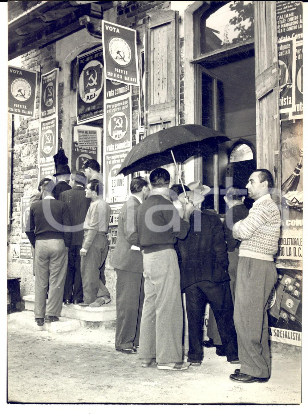 1953 SAN GIULIANO MILANESE Elezioni - Code ai seggi sotto la pioggia *Foto 13x18 Fotografia d'epoca, con didascalia coeva al verso. CONDIZIONI: G (sovraimpressione al margine inferiore)FORMATO: 13x18 cm    originale e autentica 1